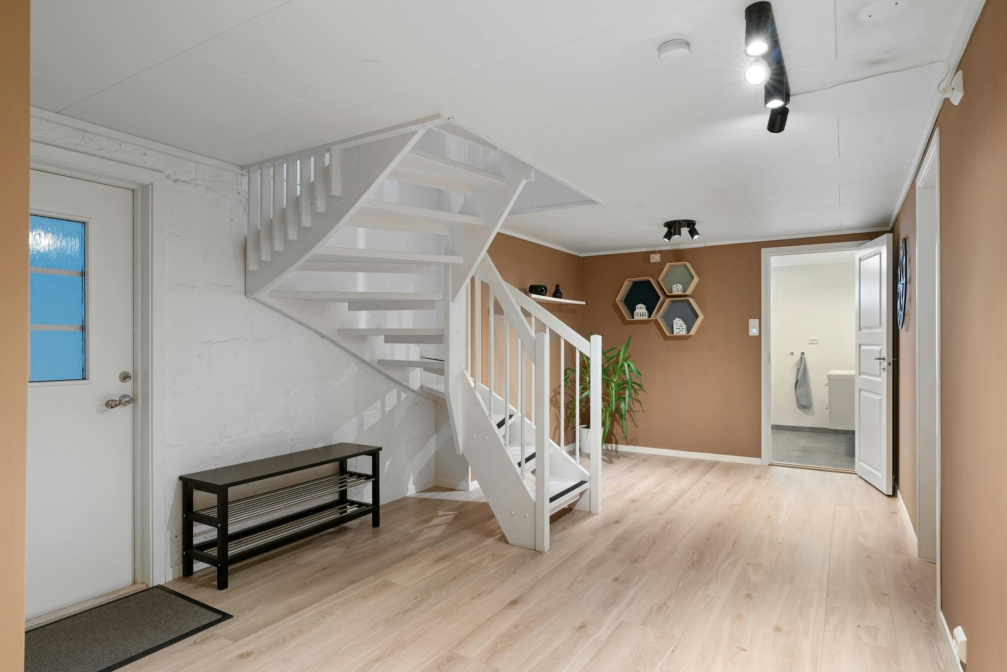 Modern apartment interior featuring a white staircase and sleek design elements.